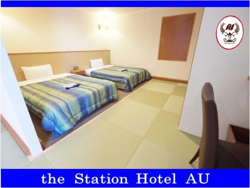 A bed or beds in a room at Station Hotel AU