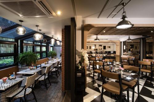 a restaurant with tables and chairs in a room at De Chai the Deco Chiang Mai - SHA Plus in Chiang Mai