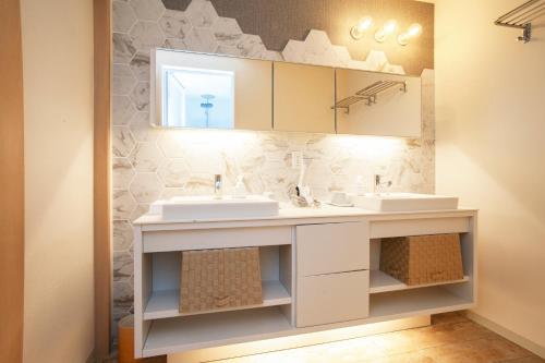 a bathroom with two sinks and a mirror at GRAND BASE Osu in Nagoya