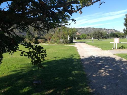 a walkway through a park with a green field at The Gamtoos Ferry Hotel in Jeffreys Bay