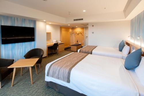 a hotel room with two beds and a desk at Narita Tobu Hotel Airport in Narita