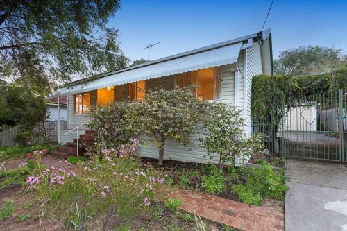 a white house with a fence in front of it at Camellia Cottage - PET FRIENDLY - Kwinana in Medina