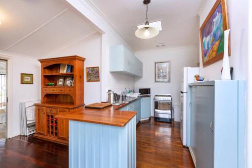 a kitchen with a refrigerator and a wooden counter top at Camellia Cottage - PET FRIENDLY - Kwinana in Medina
