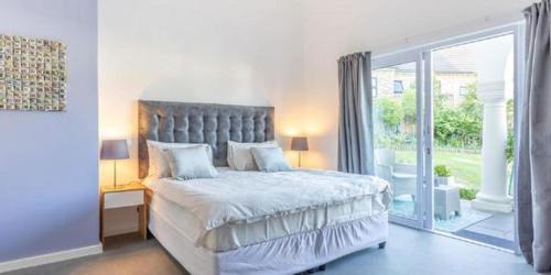 a bedroom with a large bed and a large window at The Views Guesthouse in Somerset West