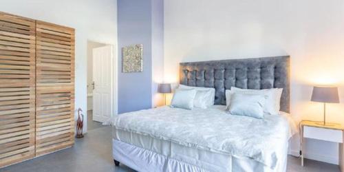 a bedroom with a large bed with a large headboard at The Views Guesthouse in Somerset West