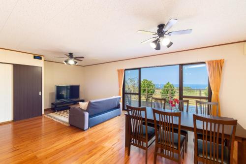 a living room with a ceiling fan and a dining room at Regina Ishigaki Ocean Yonehara / Two-Bedroom Villa in Fukai