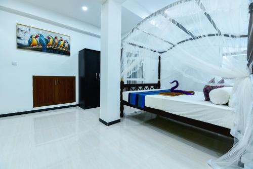 a bedroom with a bed and a painting on the wall at Peacock Beach Hotel Unawatuna in Unawatuna