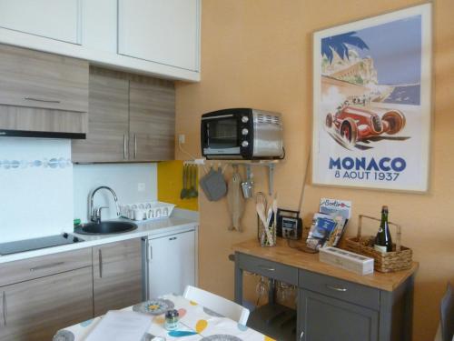une cuisine avec un évier et un micro-ondes dans l'établissement Studio Les Pieds dans l'eau, à Donville-les-Bains