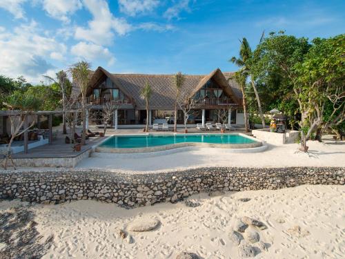 a house on the beach with a swimming pool at Villa Voyage in Nusa Lembongan