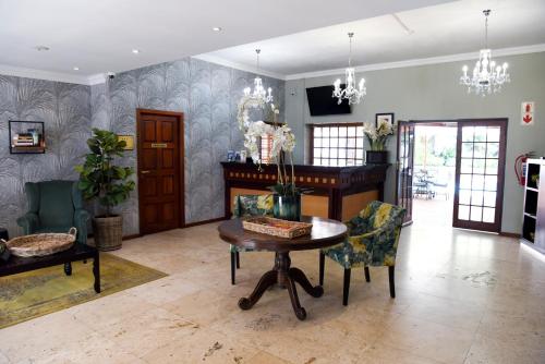 a living room with a table and chairs at Constantia Hotel and Conference Centre in Midrand