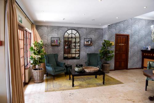 a living room with two chairs and a table at Constantia Hotel and Conference Centre in Midrand