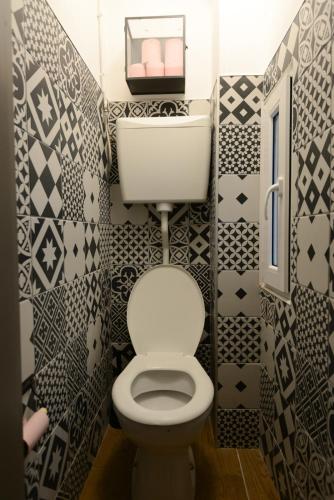 a bathroom with a toilet with black and white tiles at LAFAYETTE HOTEL in Paris