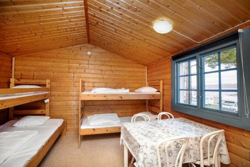 スンツヴァルにあるFirst Camp Fläsian - Sundsvallの二段ベッド2台とテーブルが備わる客室です。
