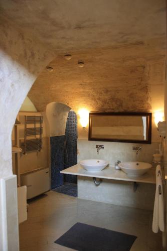 a bathroom with two sinks and a mirror at Locus Amoenus in Matera