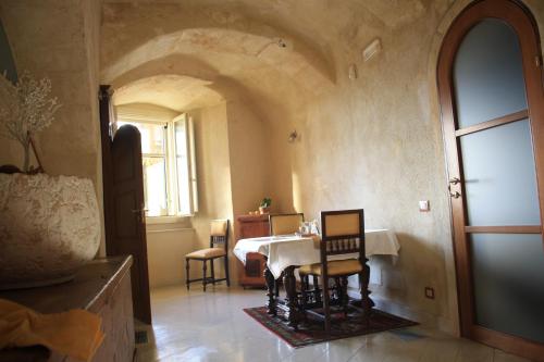 a room with a table and chairs and a window at Locus Amoenus in Matera