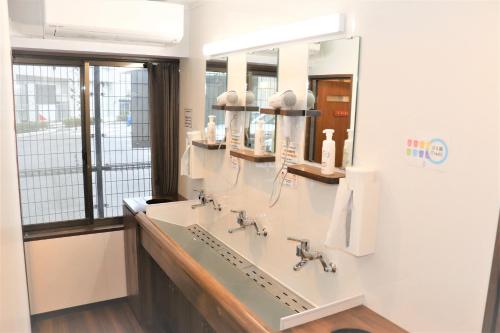 a bathroom with two sinks and a large mirror at JAM HOSTEL Hakata Station Front in Fukuoka