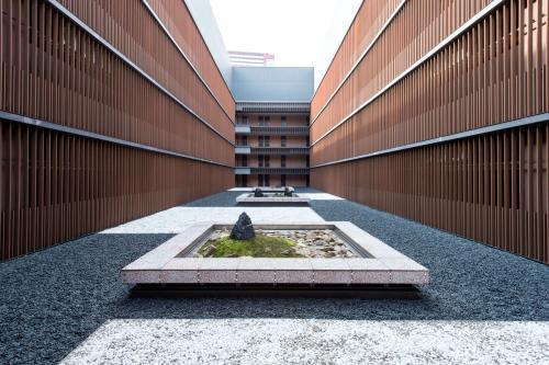 a courtyard with a fountain in the middle of a building at Villa Fontaine Grand Tokyo Tamachi in Tokyo