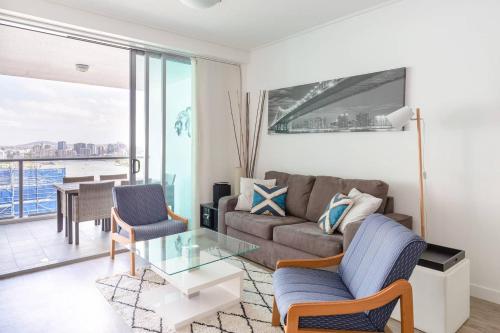 a living room with a couch and a glass table at Brisbane City Apartments (Tank St CBD) in Brisbane