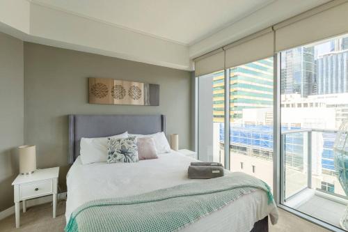 a bedroom with a bed and a large window at Brisbane City Apartments (Tank St CBD) in Brisbane