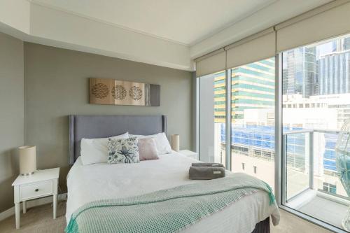 a bedroom with a bed and a large window at S&P Apartments - Tank St in Brisbane
