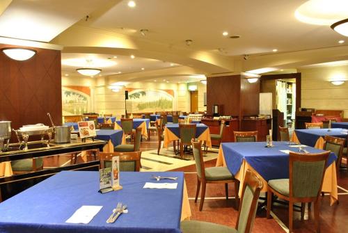 restauracja z niebieskimi stołami i krzesłami oraz stołówka w obiekcie Hotel Yokohama Camelot Japan w mieście Jokohama