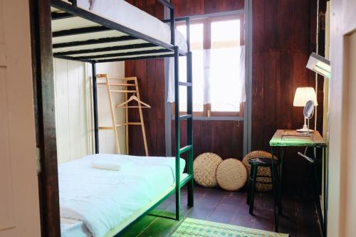 a bedroom with a bunk bed and a window at บ้านเสงี่ยม-มณี Baan Sa ngiam-Manee in Sakon Nakhon