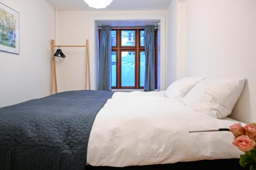 a bedroom with a large white bed with a window at Sanders Park - Charming 1-Bdr Apt Close to Metro in Copenhagen