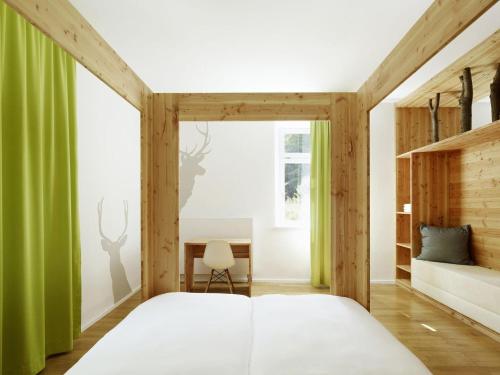 a bedroom with a large bed and a desk at seehaus forelle haeckenhaus in Ramsen