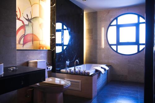 La salle de bains est pourvue d'une baignoire, de toilettes et d'une fenêtre. dans l'établissement Long Beach Garden Hotel & Pavilions, à Pattaya (nord)