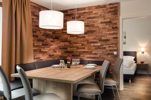 een eetkamer met een houten tafel en stoelen bij AlpenParks Chalet & Apartment AreitXpress in Zell am See