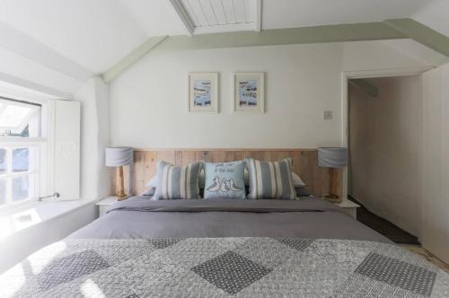 um quarto com uma cama, 2 candeeiros e uma janela em Gulls Perch em Portloe