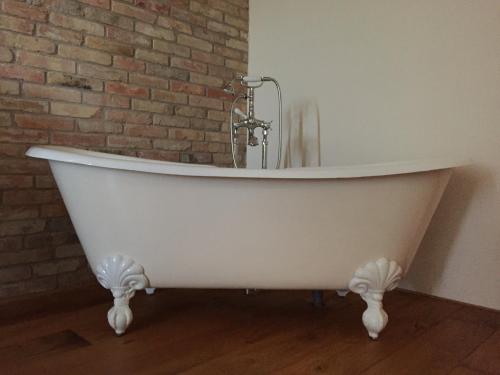 a white bath tub in a room with a brick wall at La Locanda Paradiso in SantʼEgidio