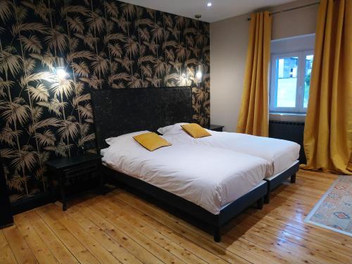 1 dormitorio con 1 cama con sábanas blancas y almohadas amarillas en Gîte 1942 - Verdun en Ville-devant-Chaumont