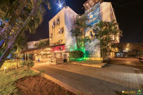 a building with green lights on the side of it at Hotel Ashwin Igatpuri, Pure Veg & Jain Food in Igatpuri