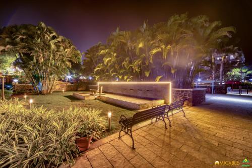 a bench in a park at night with lights at Hotel Ashwin Igatpuri, Pure Veg & Jain Food in Igatpuri
