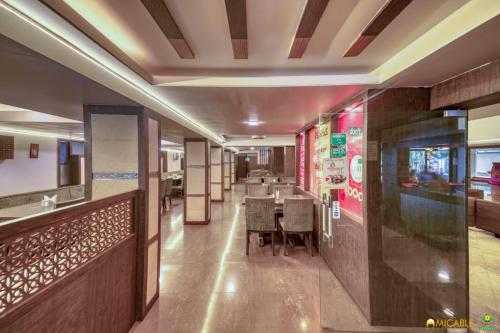 a restaurant with a table and chairs in a room at Hotel Ashwin Igatpuri, Pure Veg & Jain Food in Igatpuri