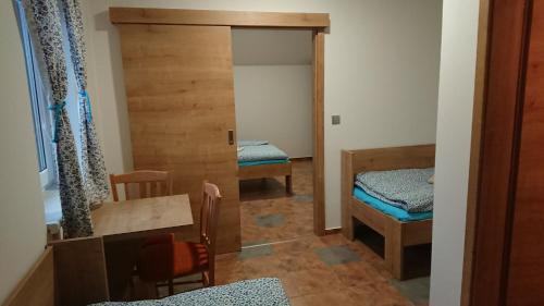 a room with two beds and a door to a bedroom at Sklep Lada in Moravský Žižkov