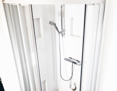 a shower in a bathroom with a glass door at Violette avec parking privé sécurisé in Saint-Valery-sur-Somme