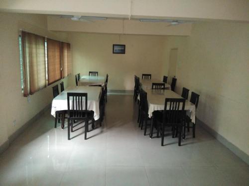 a dining room with tables and chairs in it at The Salvation Army RED SHIELD GUEST HOUSE in Kolkata