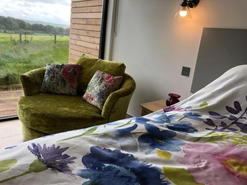 um quarto com uma cama, uma cadeira e uma janela em Tweed Hideaway em Kelso