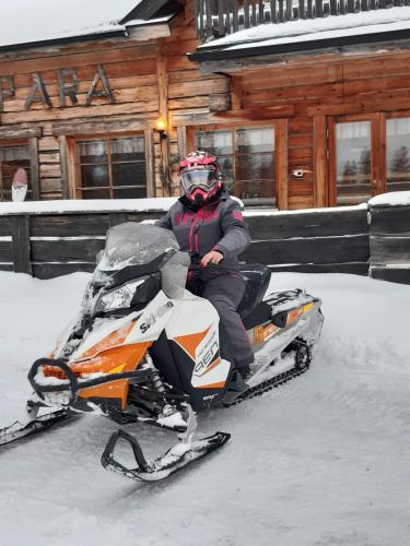 a person riding on a snowmobile in the snow at Villa Karhunkehto in Luosto