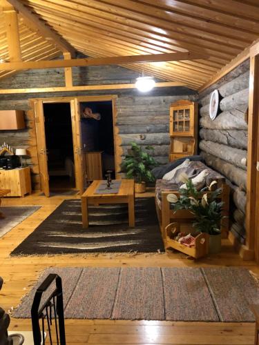 a log cabin room with a bed and a table at Villa Karhunkehto in Luosto
