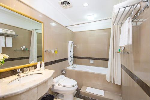 a bathroom with a sink and a toilet and a tub at Blue Sky Pandurata Hotel Cikini in Jakarta