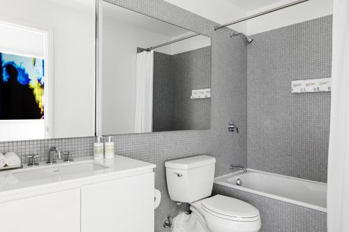 a bathroom with a toilet and a sink and a tub at  Liz by Black Swan - DC Executive Flat in Washington, D.C.