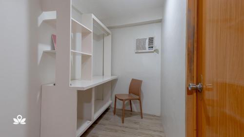 a room with white shelves and a chair and a door at Happy Grey Hotel Vigan in Vigan