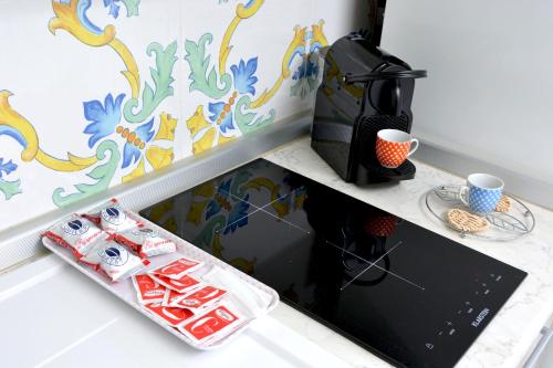 a kitchen with a counter with a coffee maker and cups at La Bomboniera in Maiori