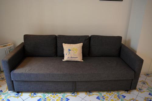 a gray couch with a pillow on it in a room at La Bomboniera in Maiori