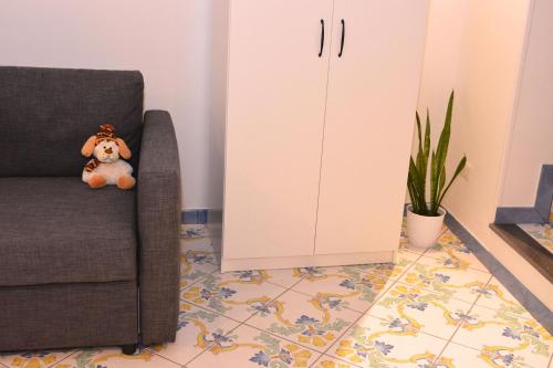 a teddy bear sitting on a chair in a living room at La Bomboniera in Maiori
