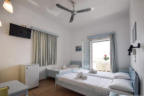 a hotel room with two beds and a window at Hotel Ivi in Drios
