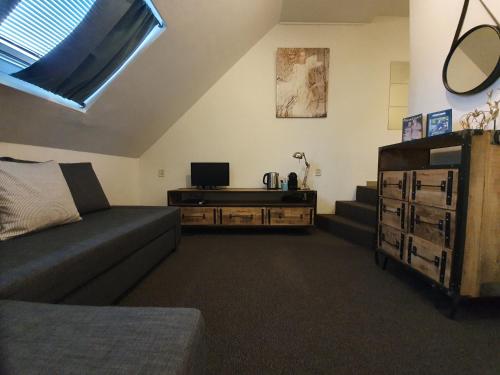 a living room with a couch and a television at Slapen Bij Brownies & Downies in Valkenswaard